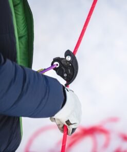 Escalador utilizando el asegurador Vergo Trango negro con cuerda roja en entorno invernal.