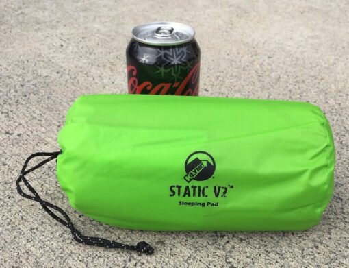 Colchoneta Klymit Static V2 empaquetada junto a una lata para mostrar su tamaño compacto