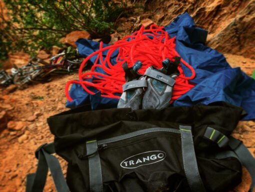 Bolsa Trango Antidote abierta con cuerda de escalada desplegada sobre lona en entorno rocoso