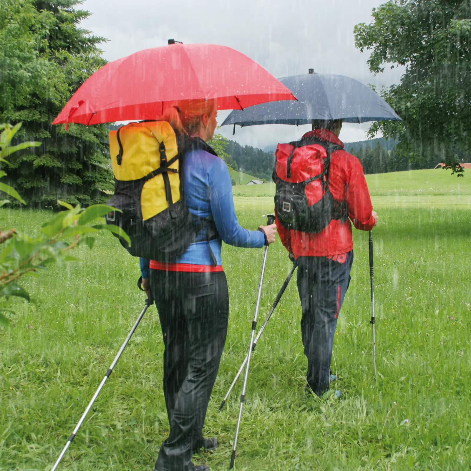 Dos senderistas con mochilas y bastones durante una ruta de trekking